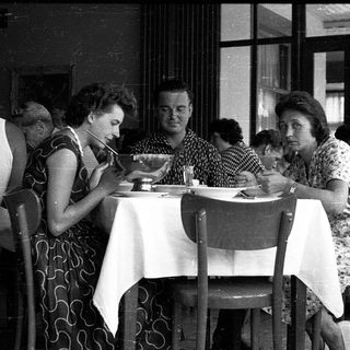 People dining together in a café, mid-20th century.