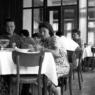 People dining together in a café, mid-20th century.