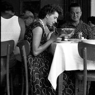 People dining together in a café, mid-20th century.