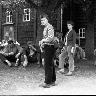 Group of people gathered outdoors, likely in a rural setting.