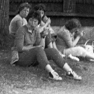 Group of people gathered outdoors, likely in a rural setting.