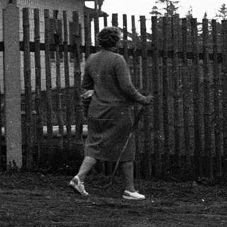 Two people near a watchtower with fenced area.