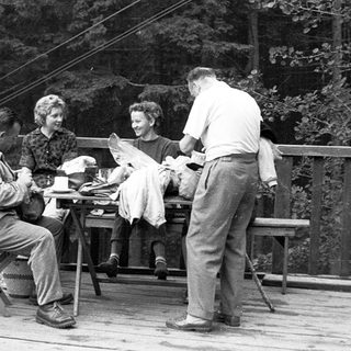 People enjoying a meal outdoors on a porch.