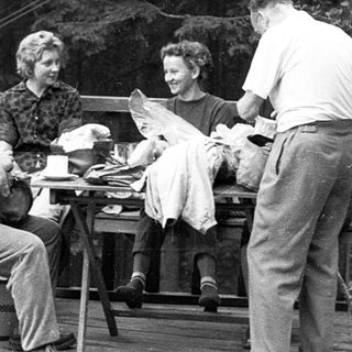 People enjoying a meal outdoors on a porch.