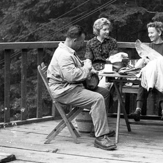 People enjoying a meal outdoors on a porch.