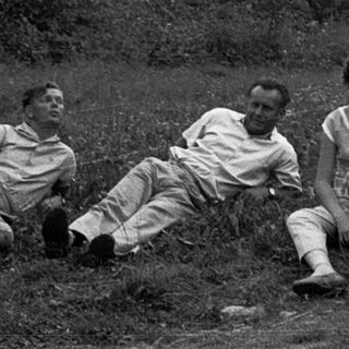 Three people sitting outdoors near ancient stone ruins.