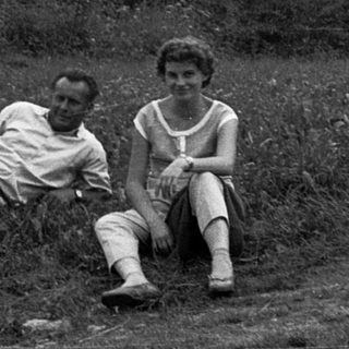 Three people sitting outdoors near ancient stone ruins.