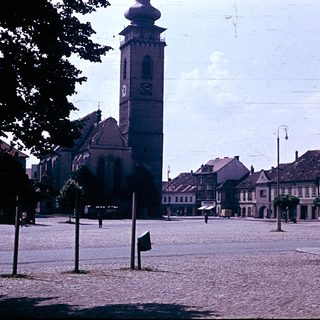 Historic town square with church tower and old buildings.