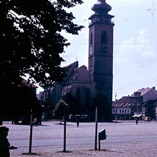 Historic town square with church tower and old buildings.