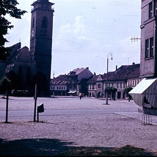 Historic town square with church tower and cobblestone streets.