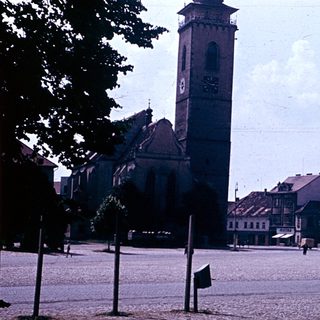 Historic town square with church tower and cobblestone streets.