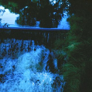 Waterfall illuminated at night.