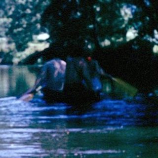 Flooded rural area with submerged trees and buildings.