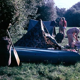 People setting up a tent and preparing for camping.