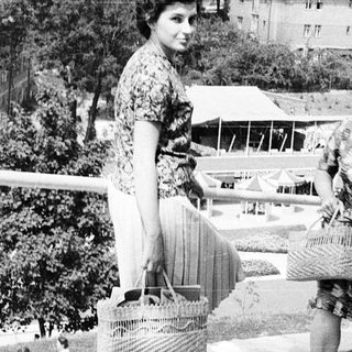 People shopping at an outdoor market with baskets.
