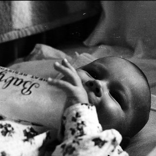 Newborn baby sleeping in hospital bassinet.