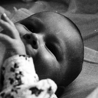 Newborn baby sleeping in hospital bassinet.