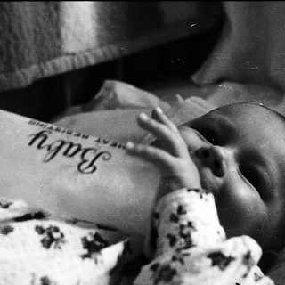 Newborn baby sleeping in hospital bassinet.