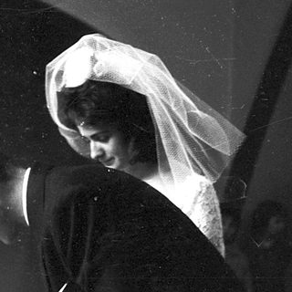 Wedding couple signing guest book indoors.