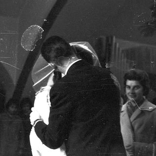 Two people dancing closely indoors at night.