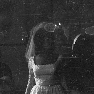 Ethereal bride with veil in dimly lit, starry setting.