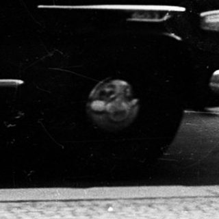 Wedding couple exiting vintage car with attendants.