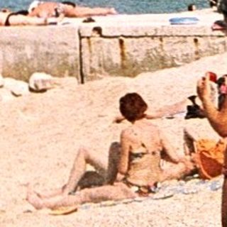 Sunny seaside beach with people relaxing.