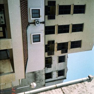 Multi-story building with aged exterior and visible wear.