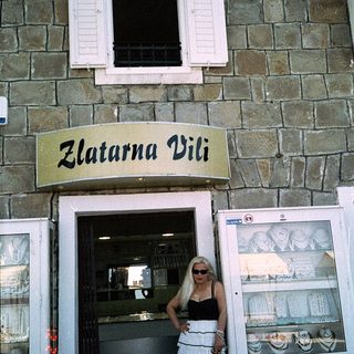 Woman posing outside goldsmith shop named "Zlatarna Vili."