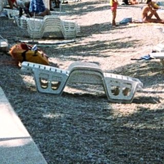 Sunny beach with people relaxing by the sea.