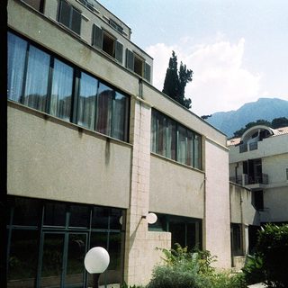 Modern building complex with mountain backdrop.