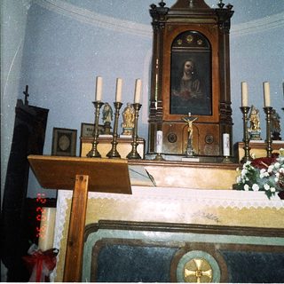 Ornate altar with religious icon, candles, and crucifix.