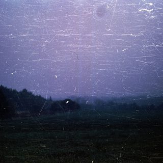 Meteor shower over dark countryside landscape.