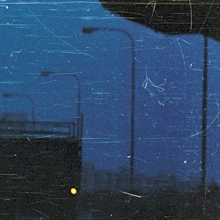 Urban night scene viewed through scratched glass.