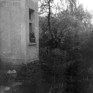 Flooded street with submerged building corner and balcony.