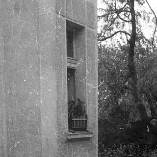 Flooded street with submerged building corner and balcony.