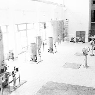 Industrial facility with large processing tanks and machinery.