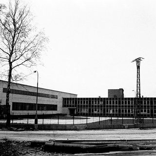 Industrial building complex with railway tracks.