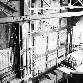 Industrial building interior with exposed machinery and scaffolding.