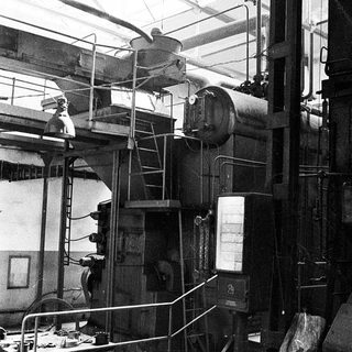 Industrial facility with large steam boiler and machinery.
