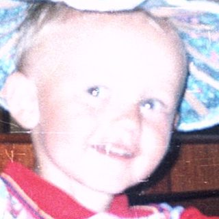 Young child wearing striped hat indoors.