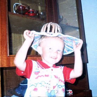 Young child wearing striped hat indoors.