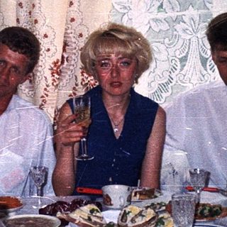 Family gathering celebrating with food and drinks indoors.