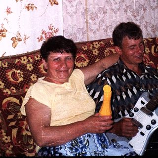 Two people playing guitar and singing together indoors.