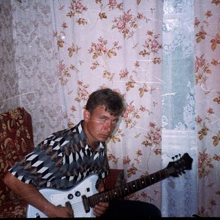 Man playing electric guitar indoors.
