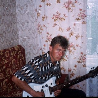 Man playing electric guitar indoors.