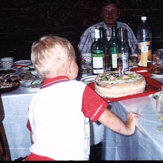 Family gathering celebrating a birthday with cake.