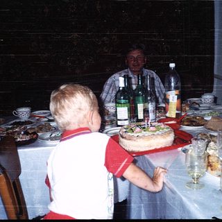 Family gathering celebrating a birthday with cake.