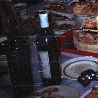 Family celebrating birthday with cake indoors.