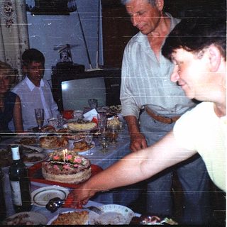 Family celebrating birthday with cake indoors.